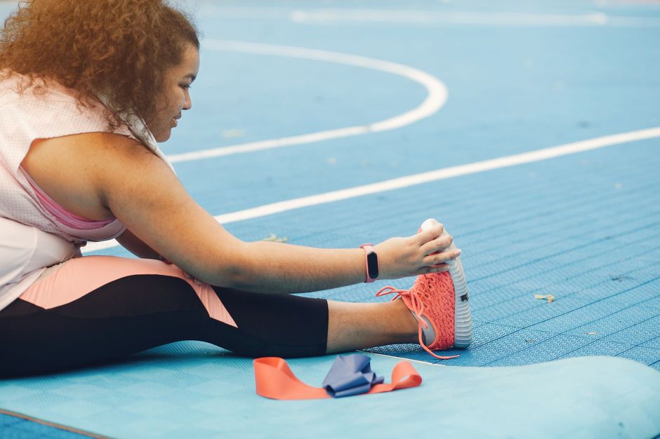 An athlete stretching with a resistance band on an outdoor sport court